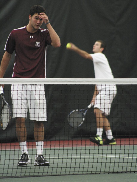 MIHS senior Max Franklin takes a quick breather as his doubles teammate Andrew Smith prepares to serve the ball during the duo’s quarterfinal match against Bellevue on Monday afternoon.