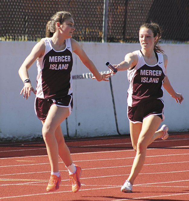 Mercer Island's Emily Lightfoot hands off to Lauren Emick during the Islanders 4x200 relay on Thursday