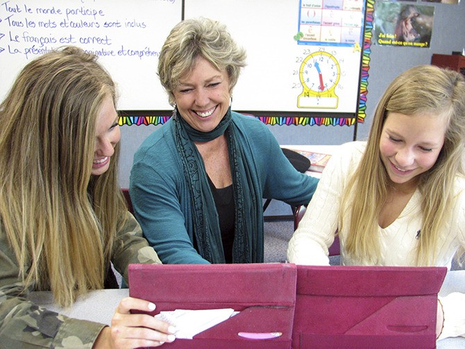 Teacher Jan Brousseau shares a laugh with students at Islander Middle School.