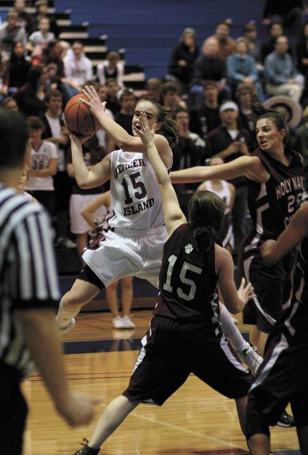 Hailey Gullstad (15) tries to get to the basket as she's guarded by Holy Names Laura Sullivan (15) during the Islanders SeaKing district championship game.