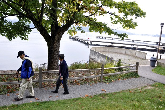 A couple strolls along the shoreline at Luther Burbank Park on a misty morning as summer gives way to fall in late September.