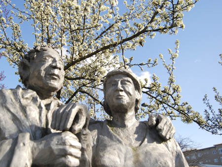 A crown of cherry blossoms adorns the statue of a senior couple outside QFC on the North-end of the Island on March 3. The Island is enjoying an early spring this year.