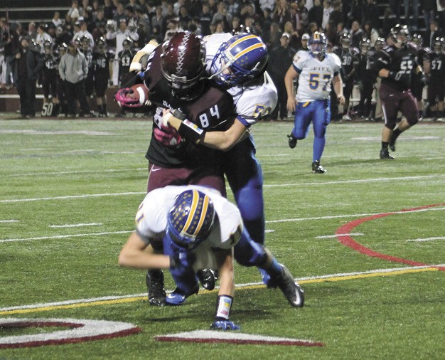 Mercer Island senior Zack Bucklin is wrapped up by Fife defensive players during the Islanders non conference win over the Trojans on Friday