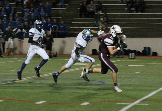 Mercer Island's Jackson Caputo (21) breaks past the Liberty secondary after hauling in a 38-yard touchdown pass from Griffin Kane Friday night at Islander Stadium. The Islanders beat the Patriots