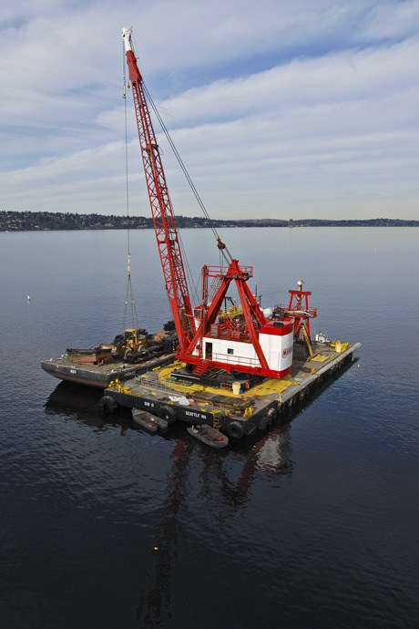 A floating work barge and crane for the shoreline reconstruction project underway near the westbound Interstate 90 bridge on the west side of Mercer Island.