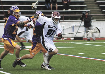 Senior captain Conner Beckwith (21) fends off Issaquah defenders during the Islanders home win over the Eagles in last Wednesday's state semifinal game.