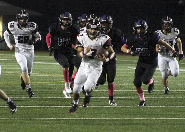 Mercer Island's Alfonso Gonzalez scrambles past Lake Washington defenders for a 38-yard touchdown run during the first half of the Islanders' 49-13 win over the Kangs.