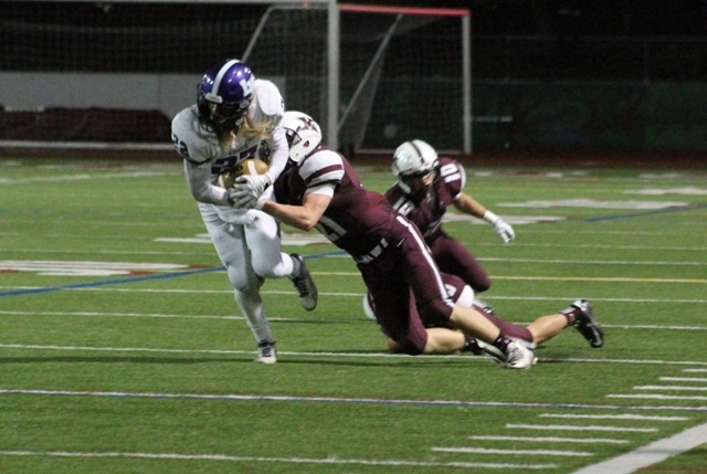 Lake Washington wide receiver Jake Wikel fights to break loose from Mercer Island's Jackson Caputo (21) and Griffin Kane (10) Friday night at Islander Stadium. The Kangs beat the Islanders