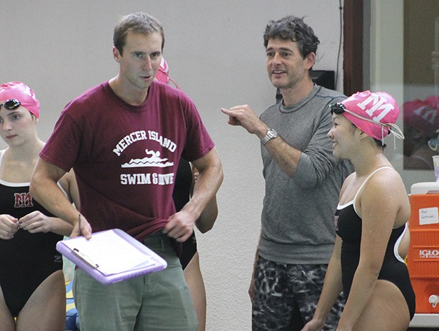 Girls swim and dive coach Chris Conroy (holding clipboard) chats with senior captain Jacque Li during the Islanders’ meet with Woodinville Oct. 8 at Mary Wayte Pool.