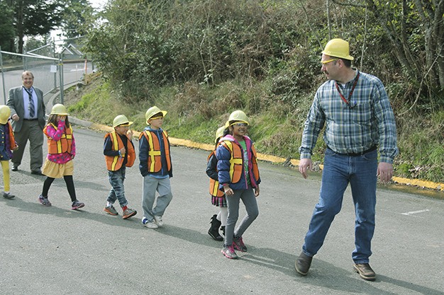 Mercer Island School District maintenance and operations director Tony Kuhn leads a group of elementary students to the future site of the new Elementary No. 4 Tuesday