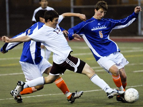 Islander Danny Strome (13) is slowed by a Lions defender during a state playoff game at Mercer Island on April 19