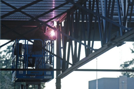 A welder works high in the beams of the PEAK construction site along 86th Avenue S.E. on Wednesday