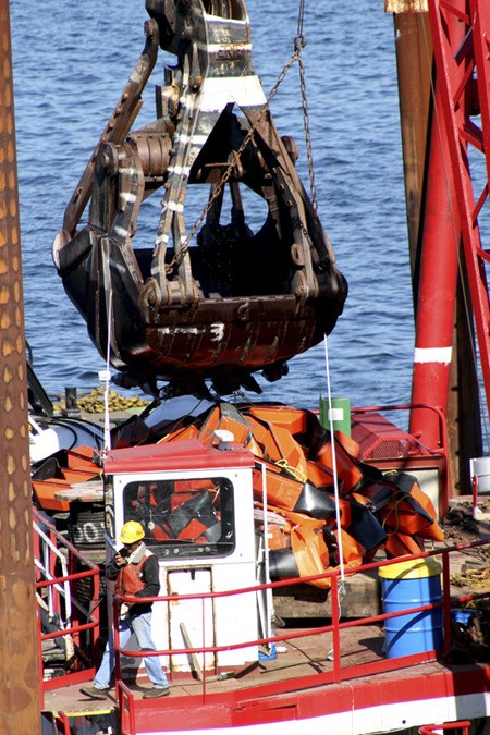 A Mason Construction crane goes to work pulling up debris from the bottom of Lake Washington as part of the 2009-2010 Sewer Lake Line project.