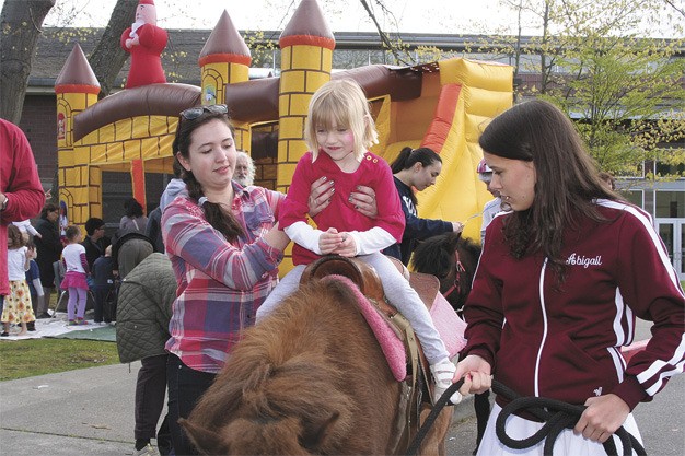 Addison Parmenter rides a pony led by MIHS freshman Abigail Jemley