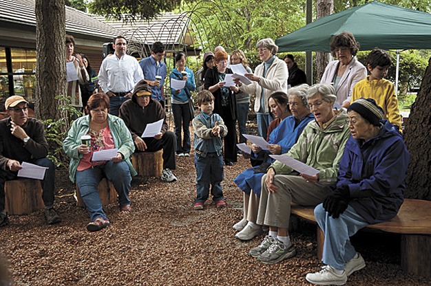 Community members gather at an opening celebration for a new community garden space at the Mercer Island Library. The garden was designed and built by community members under the guidance of Pomegranate Center