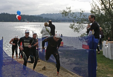 The first swimmers in the two-mile race cross the finish line of the Swim Across America event last Saturday.