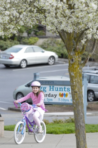 A girl rides her bike with pink tassels through Mercerdale Park on Mercer Island last Wednesday