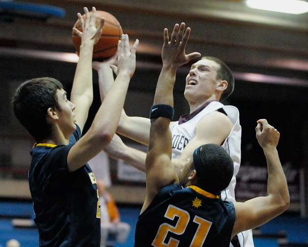 Islander forward Brian Miller drives to the basket against Bellevue defenders Cole Walton