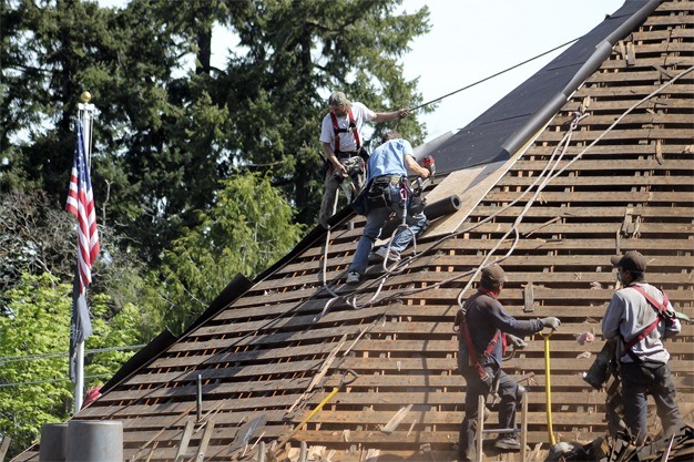 The Roof Doctor workers replace the VFW Hall roof on Monday