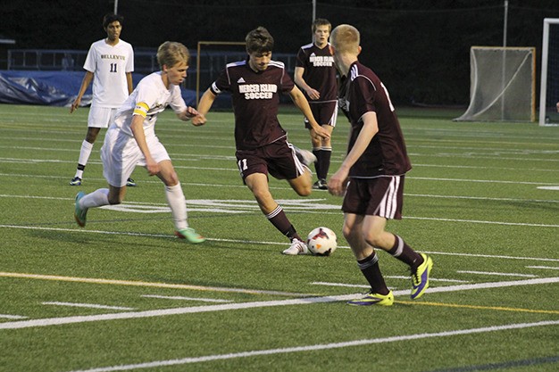 Mercer Island's Nate Schuler dribbles past Bellevue's Bennett Bugbee Wednesday