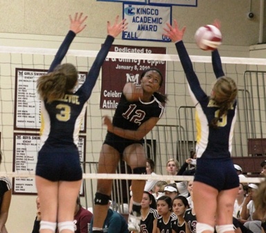 Mercer Island's Jemma Yeadon (12) spikes the ball past Bellevue's Denali Conway (3) and Ally Witham (9) Thursday night at MIHS. The Islanders beat the Wolverines 25-12