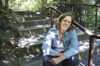 Walker and author Kris Kelsay pauses on the steps that climb the hillside above Mercerdale Park and Bicentennial Park. Kelsay has written and illustrated a book that details Island trails and paths.