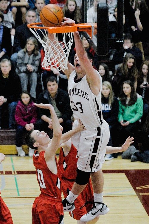 Islander forward Brian Miller (33) dunks over the Juanita defense in the first half at Mercer Island on Friday. Mercer Island beat the Rebels 67-35.