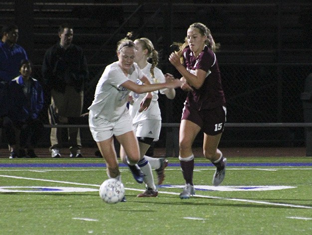 Mercer Island's Taylor Krause fights off Liberty defender Jordan Hemmen Thursday night at Liberty High School. Krause scored in the game's 78th minute to lift the Islanders over the Patriots