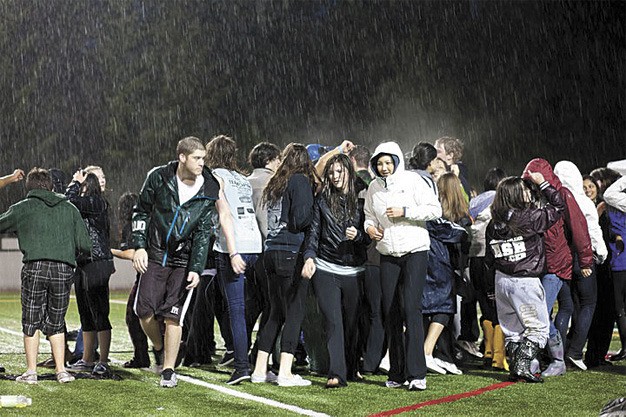 Steam rises as students dance in the rain at Islander Stadium during the deluge that hit the annual Relay for Life event on May 13-14. It was too wet to light the 600 candles set out for the Luminaria ceremony. Students brought in $90