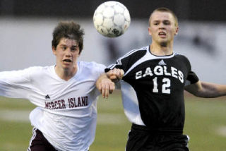 Islander Chris Morris battles a Hudson Bay opponent for possession of the ball at Islander Stadium during the first round of the state playoff tournament.