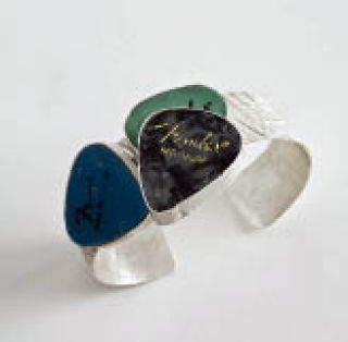 A silver bracelet entitled ‘Sheet Music’ includes three guitar picks.