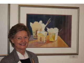 Nancy Axell stands next to her painting at the “Mischief” exhibit.