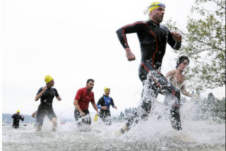 Racer Brian Carter of Sammamish splashes his way to shore during the Escape from the Rock Triathlon at Luther Burbank Park on Sunday. Over 700 people took part in the annual event. More pictures of the event can be found on page A3.