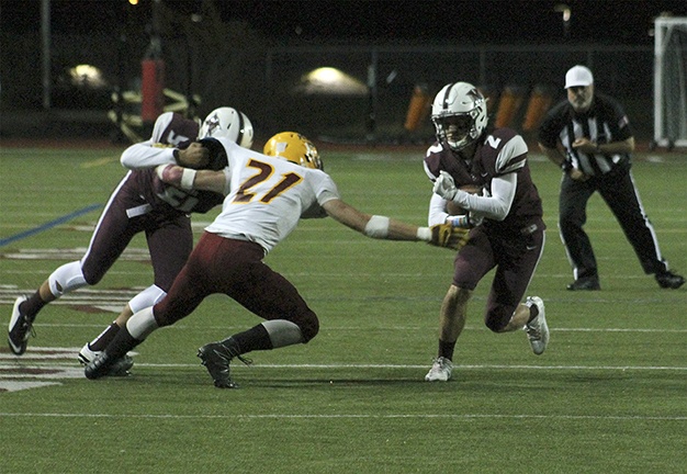 Mercer Island running back Will Dodds (2) evades Kingston linebacker Tyler Sloman (21) Friday night at Islander Stadium. The Islanders beat the Bucs 37-3 (Joe Livarchik/staff photo).