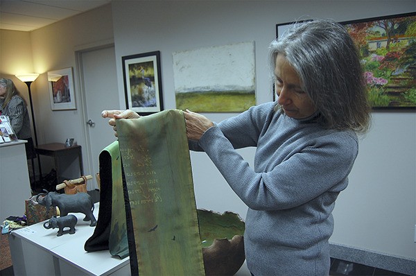 Island artist Nancy Abel shows off her silk screen scarves at the MIVAL gallery opening on Feb. 4. Abel took photos of birds at Luther Burbank Park and printed them on the fabric to create a unique effect.