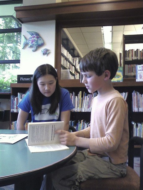 Lauren Byun (left) and Christoph Schmidt-Warnecke read together at the Mercer Island library.