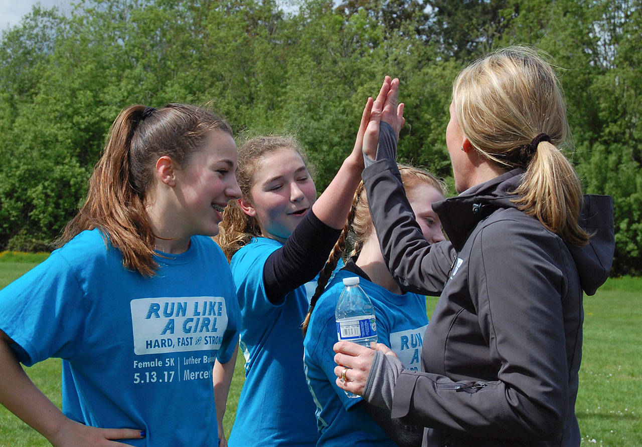 Mercer Island’s Recreation Superintendent Diane Mortenson high fives finishers of the Run Like a Girl 5K on May 13. Katie Metzger/staff photo