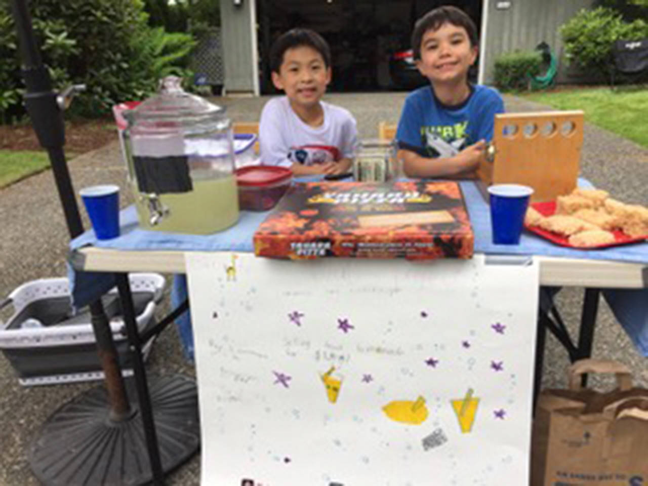 Jonathan Mak and Jens Aoyama host a lemonade and rice krispy treat stand to raise money for the Mercer Island food pantry. Photos courtesy of Kirsten Aoyama