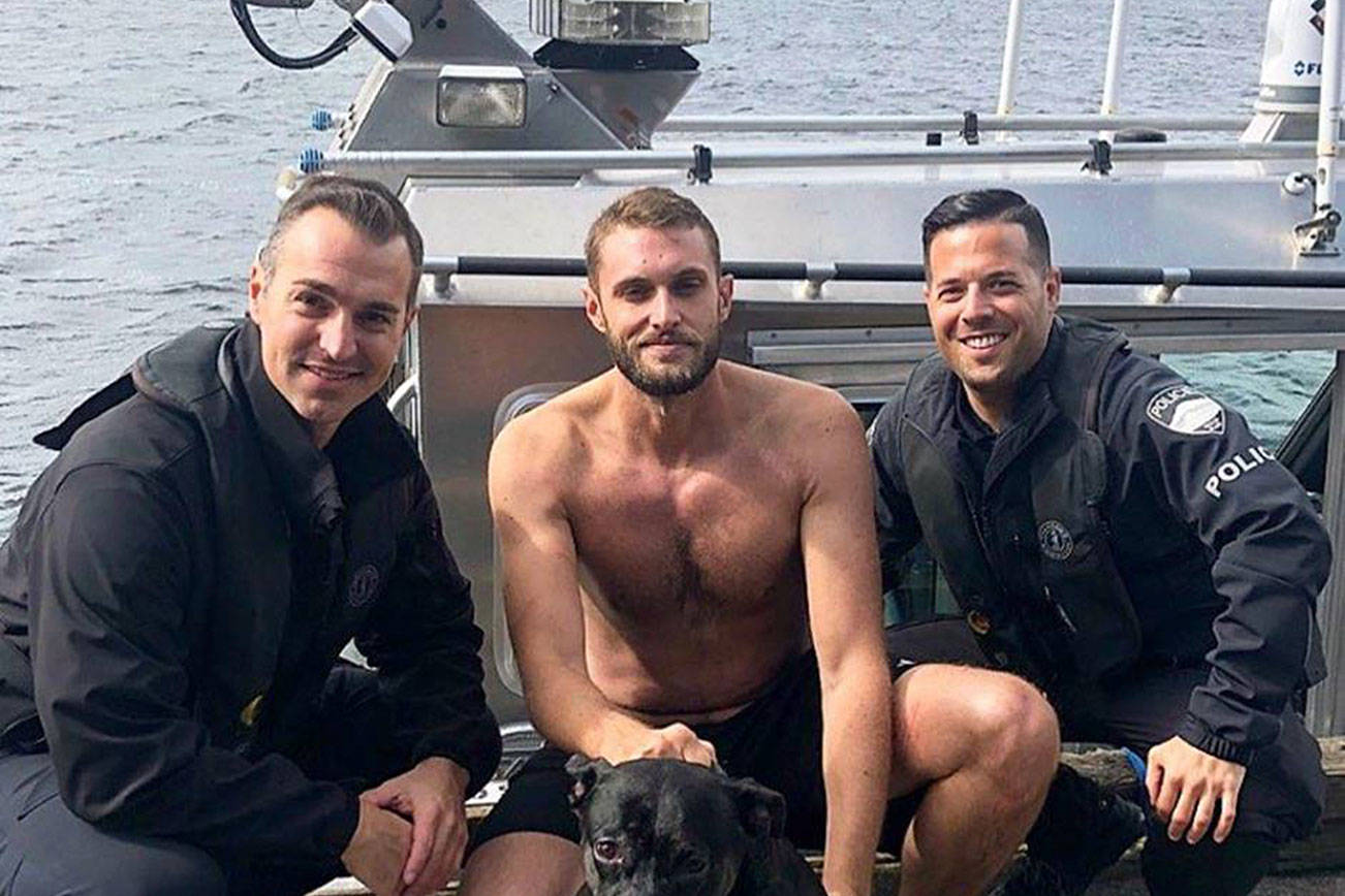 Detective Bobby Jira (left) and Cpl. David Canter (Right) pose with Nate Palmer and Juno (Center) after a successful rescue. Photo courtesy of the Mercer Island Police and Emergency Management Facebook page