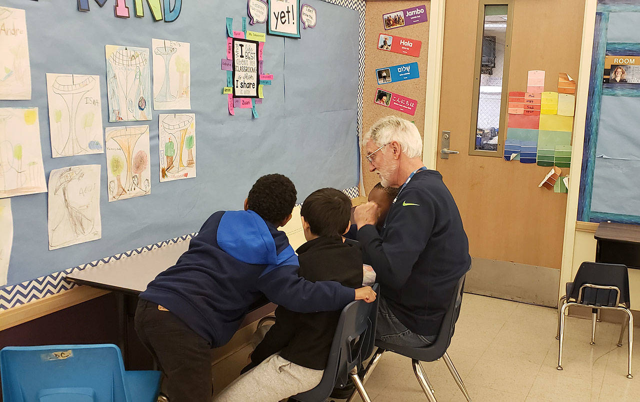 John Hamer of the Mercer Island Rotary Club tutors students at Van Asselt Elementary School in South Seattle. Photo courtesy of Nancy Lee