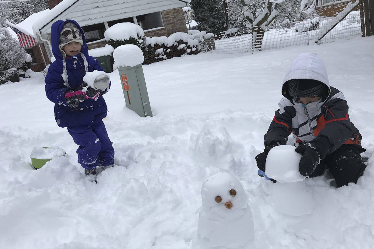 Poppy, 6, and Cassius Ethe, 9, put the finishing touches on their mini snowman. See story about the recent snow storms and more photos on Page 15. Photo courtesy of Meg Lippert