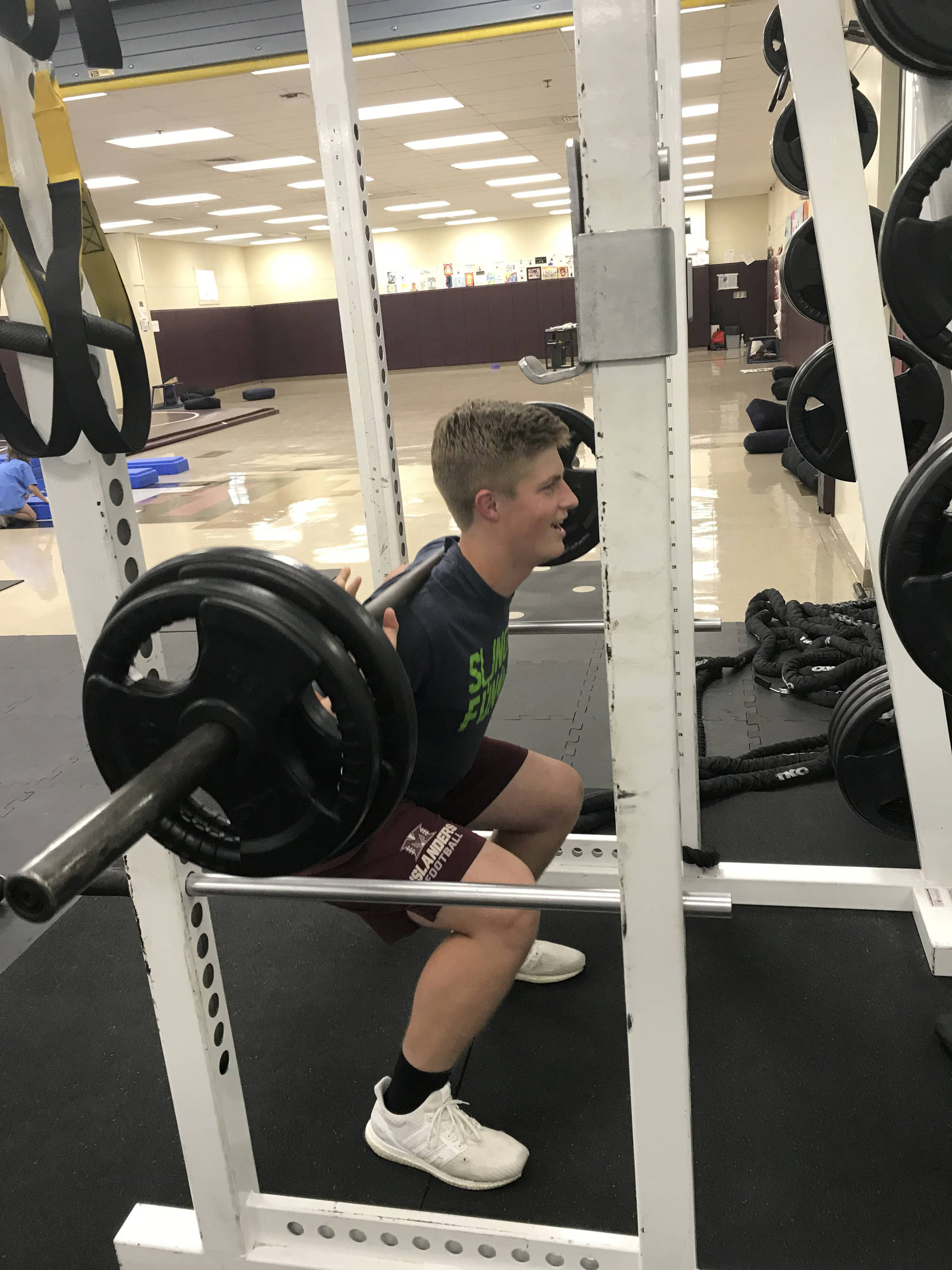 Mercer Island quarterback Clay Dippold completes a set of reps on the squat rack in the weight room on June 14. Shaun Scott/staff photo