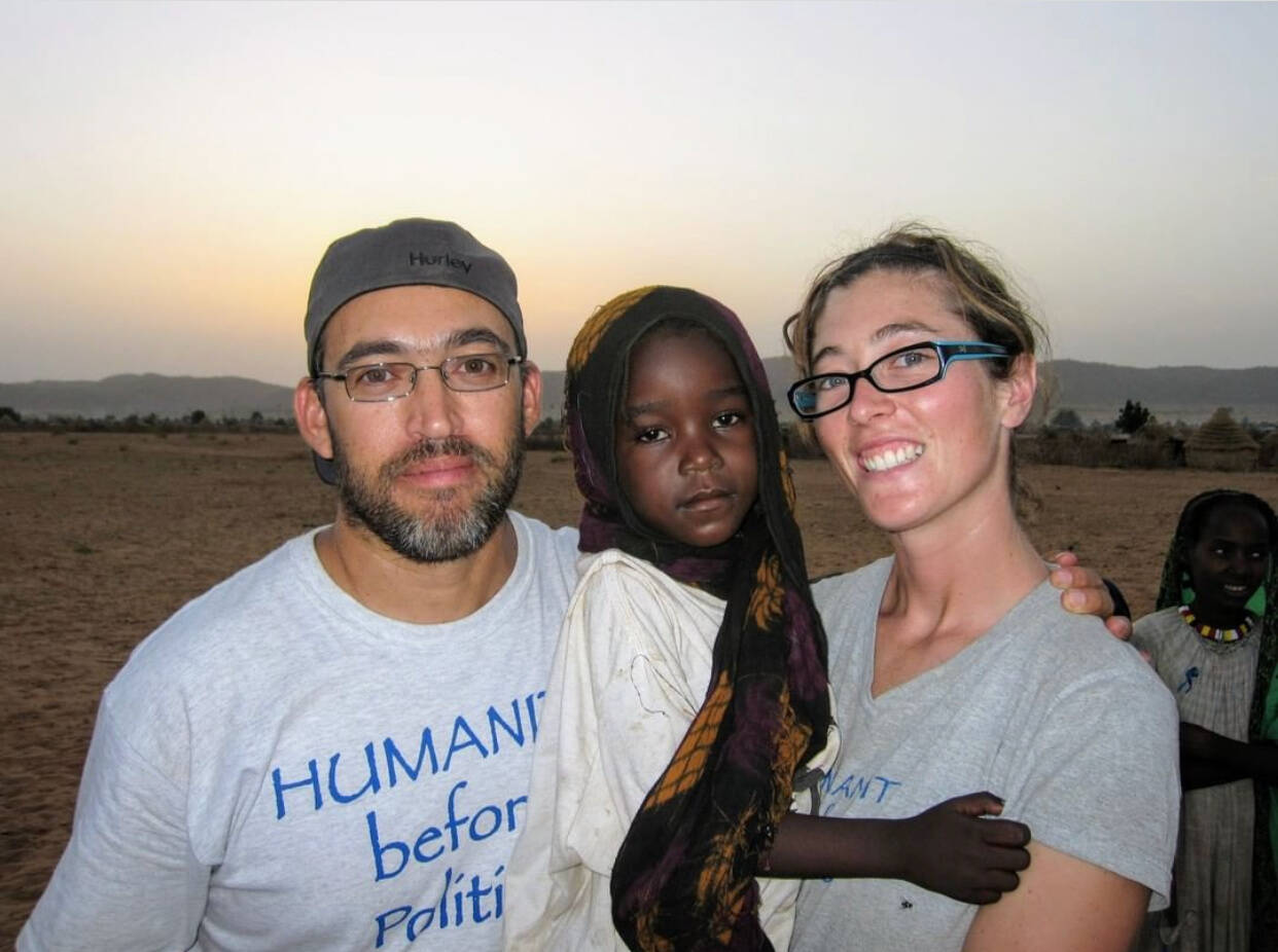 Gabriel Stauring, left, and Katie Jay Scott-Stauring, right, hold Darfuri refugee Guisma at the Djabal Refugee Camp in Eastern Chad in 2009. Photo courtesy of iACT