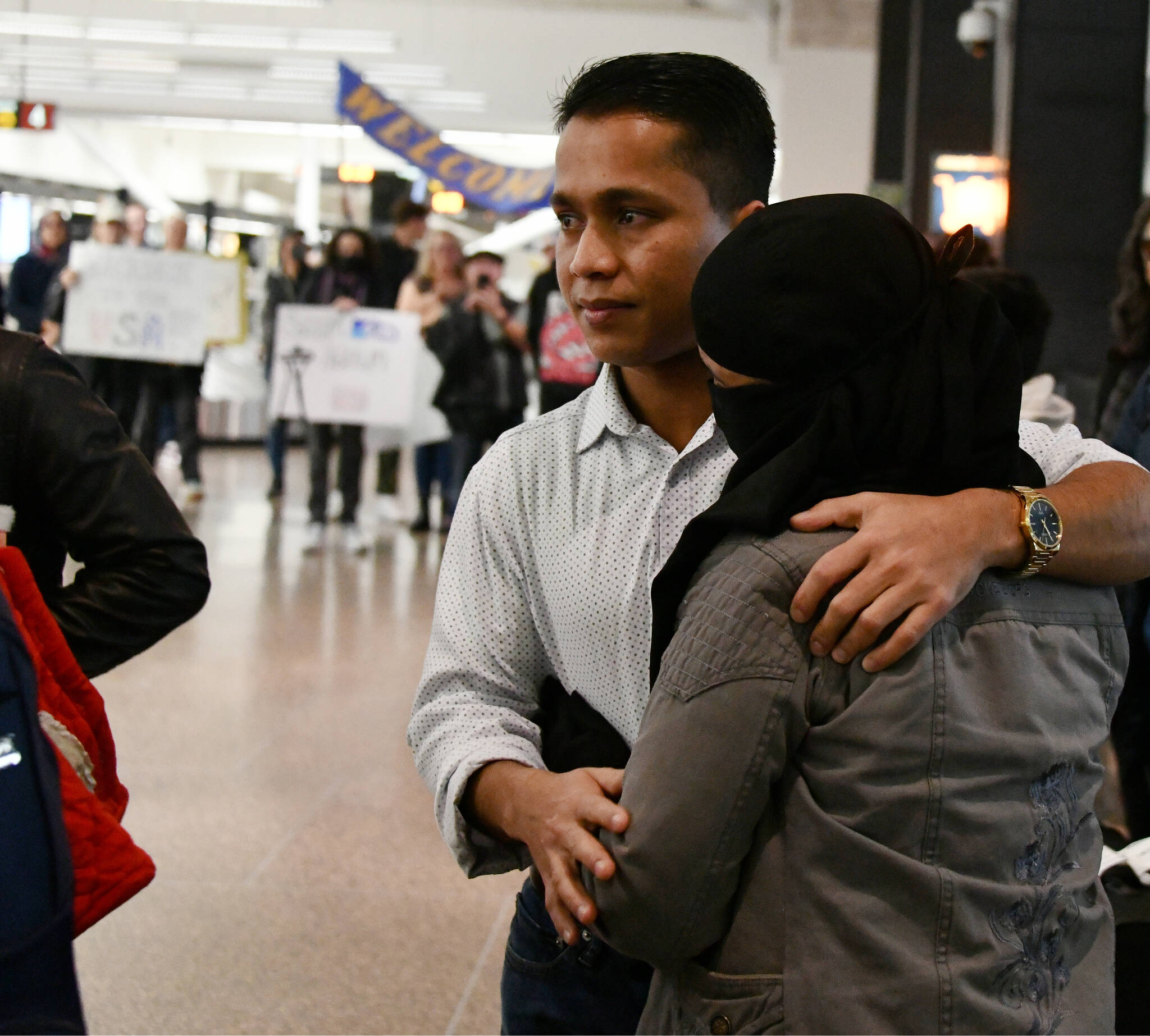 Mohamad Imran reunites with family members, some of whom he hasn’t seen since he was 12, on Dec. 8 at Seattle-Tacoma International Airport. Mercer Island friends and supporters gather in the background. Andy Nystrom/ staff photo