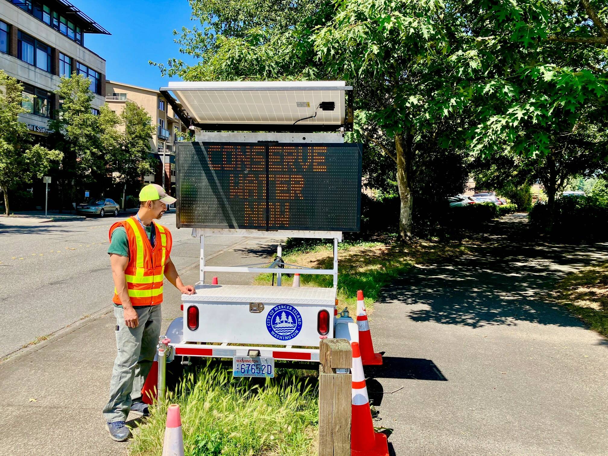 A city worker flanks a variable message sign on Mercer Island regarding immediate water conservation. Photo courtesy of the city of Mercer Island