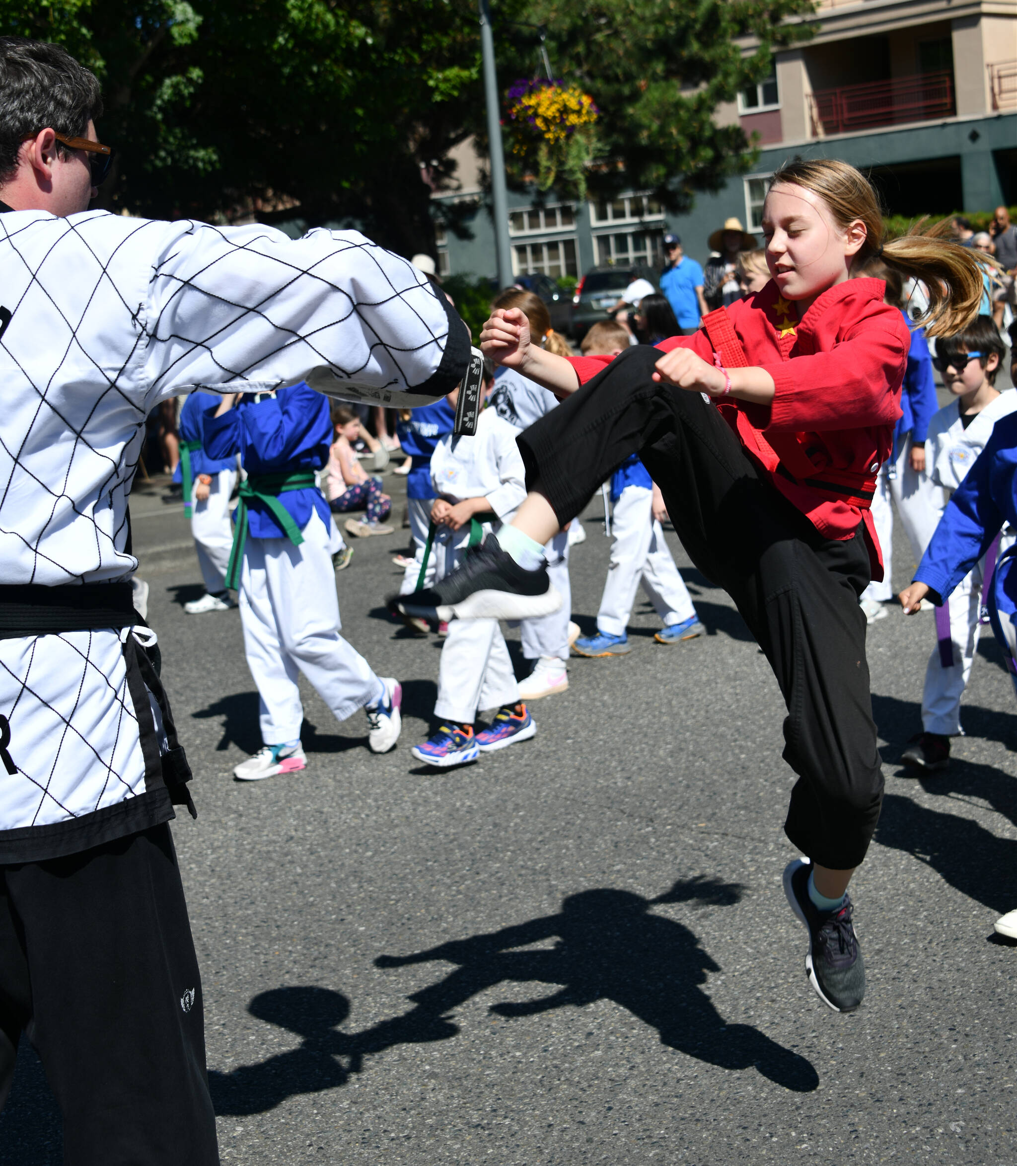 A Mercer Island Martial Arts student kicks up a storm during the community parade at Summer Celebration on July 13 along 78th Avenue Southeast. Andy Nystrom/ staff photo