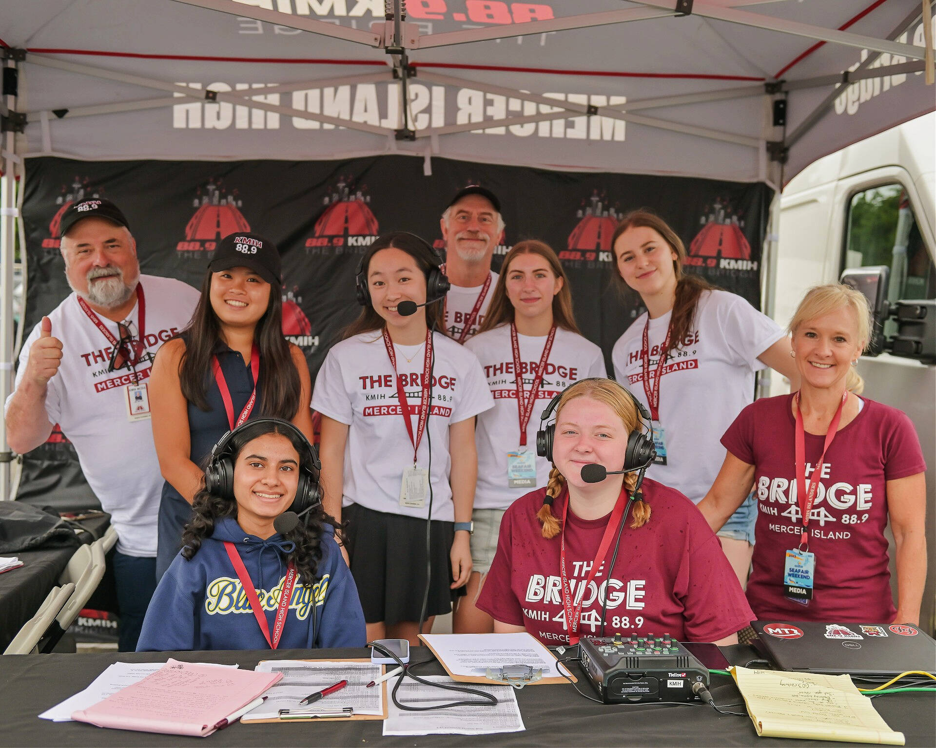 Mercer Island High School’s radio station, KMIH 88.9 The Bridge, returns with Log Boom Radio from Aug. 2-4 to broadcast the Seafair unlimited hydroplane races and Blue Angels air show. This marks 75 years of Seafair and the fifth year students have broadcast the races from Genessee Park near Lake Washington. KMIH will be located in the hydro pits all three days. “There are more students than ever volunteering to help with the broadcast and it’s awesome to see so many young people excited to participate in this annual Seattle summer tradition,” reads a press release. Seafair has provided a discount code for Island residents and KMIH listeners. Use MIRADIO24 to receive 20% off Seafair weekend general admission tickets. From left to right, front: Aadyaa Singhal, Ellie Sadlier and Natalie Woods. Back: Joe Bryant, Hailey Nguyen, Chloe Yang, John Kasprick, Julia Sommerfield and Sophie Cartwright. Photo courtesy of Jeff Cook