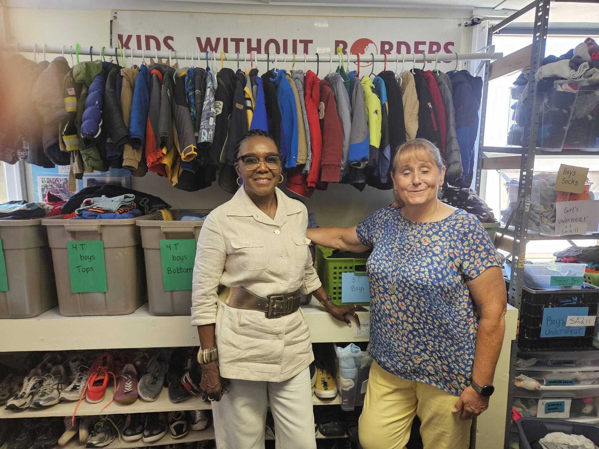 Novelett Cotter of Mercer Island and Katrina Dohn of Tukwila Rotary Clubs, at “Kids Without Borders” Children’s Clothing Bank, started by Dohn. (Photo by John Hamer)