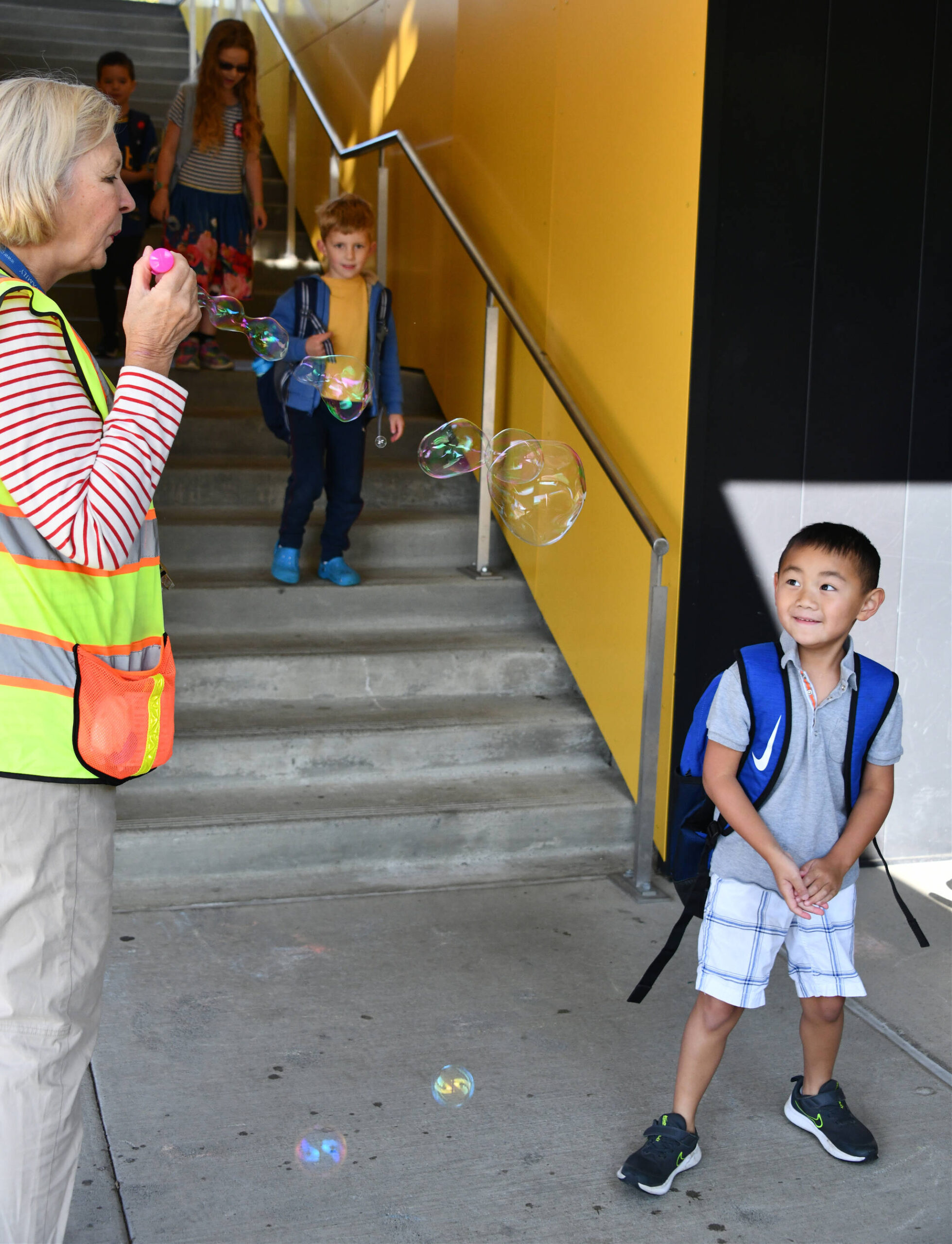 Northwood Elementary paraprofessional Katty Clark greets students with bubbles on the first day of school on Aug. 28. Andy Nystrom/ staff photo