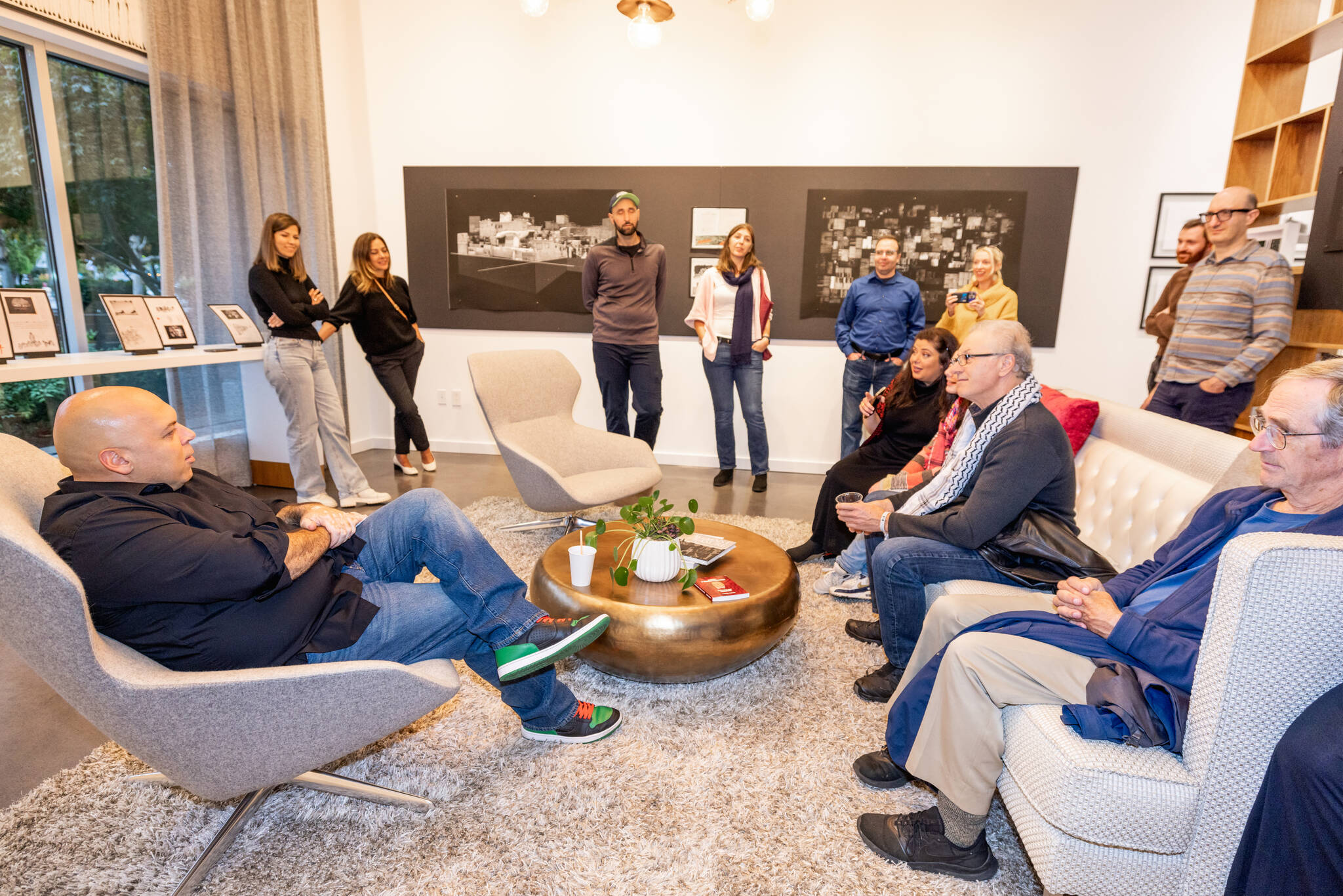 Amer Zahr (left), a Palestinian Arab American comedian, speaker, writer, academic and adjunct professor at University of Detroit Mercy School of Law, meets with attendees at the SZ Gallery on Oct. 11 on Mercer Island. Also pictured is a portion of the “Control Anatomy” exhibit by Palestinian artist Mahmoud Alhaj. Photo courtesy of Flora Art Life